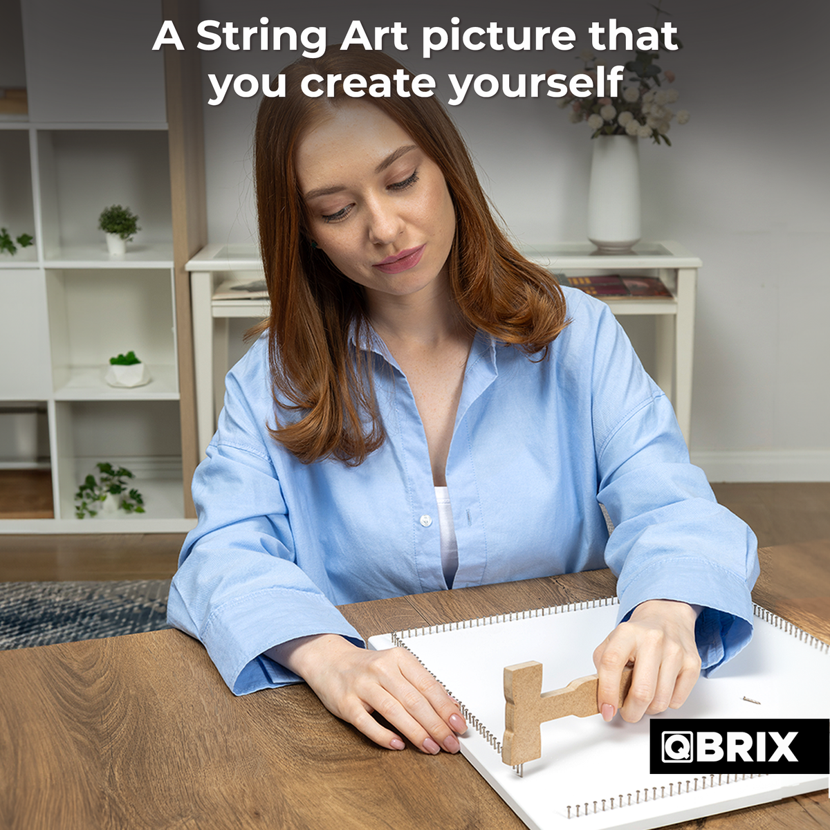 Woman creating a custom QBRIX string art picture using thread and a frame
