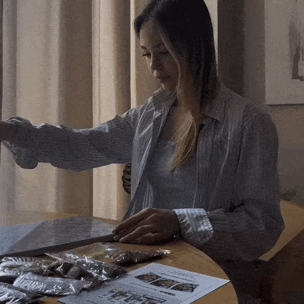 Woman sitting at a table with food packages and a menu in a restaurant setting.